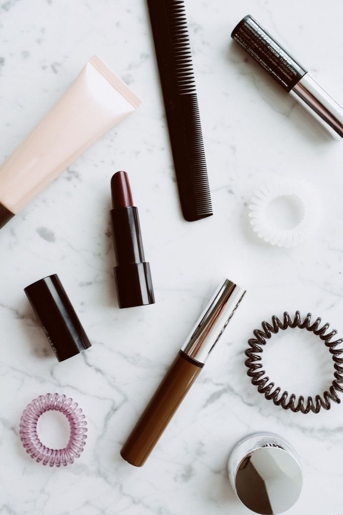 Top view of various cosmetic products for makeup and beauty style composed on white background with marble pattern